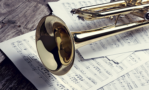 Eine Trompete liegt auf mehreren Notenblättern.