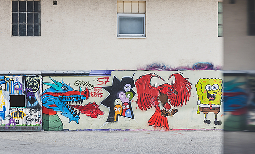 Eine Wand, die mit Graffitis besprüht ist.