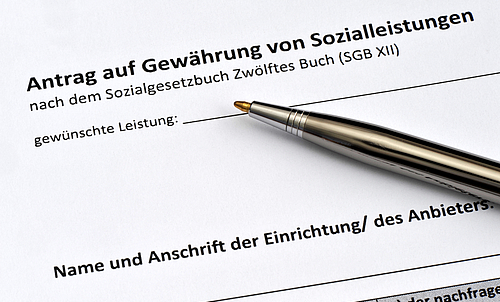 Ein Antrag auf Gewährung von Sozialleistungen, auf dem Antrag liegt ein Stift.