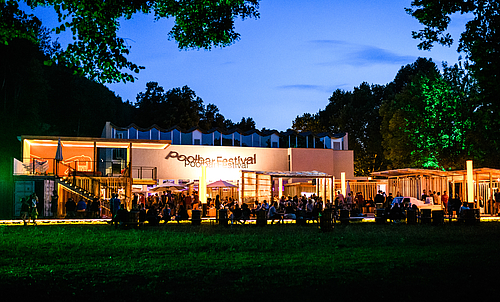 Das Poolbar-Festival im Außenbereich des Alten Hallenbads bei Abend.
