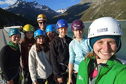Eine Gruppe junger Personen mit Helm im alpinen Gelände