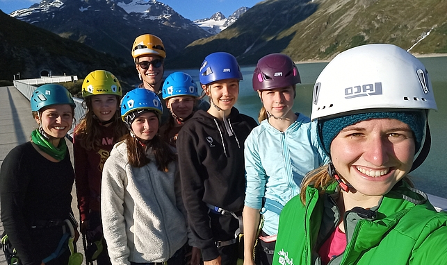 Eine Gruppe junger Personen mit Helm im alpinen Gelände