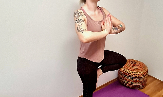 Frau mach Yoga auf einer pinken Matte